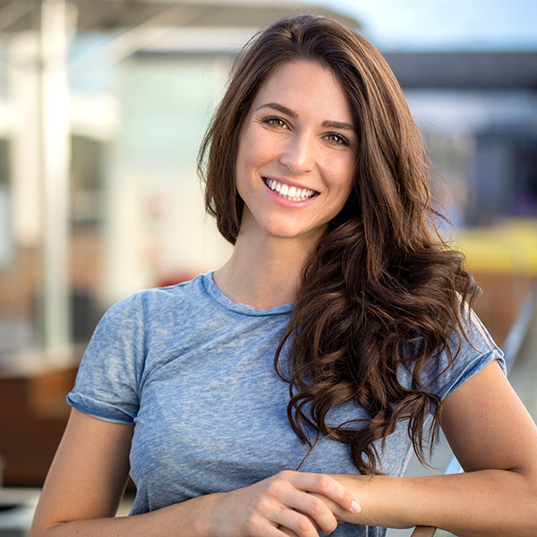 Your First Visit Brunette Woman Smiling Outdoors